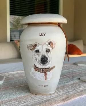 Ceramic urn with a dog picture painted on it. 