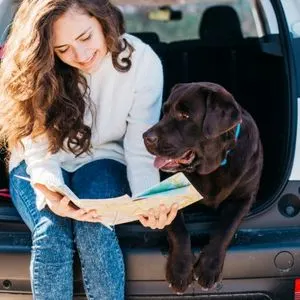 Traveling With A Dog: Tips For An Easy Trip - women and brown lab looking at map.