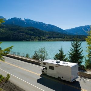 RV driving on the road near a lake