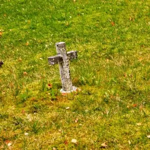 Small stone cross in grass