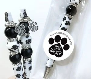 Beaded pen with paw prints and hanging dog paw that states " Thanks for Being the Best dog Walker. 