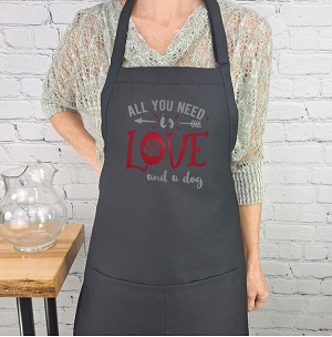 Gray dog mom apron with "All you need is love and a dog" written on it. 