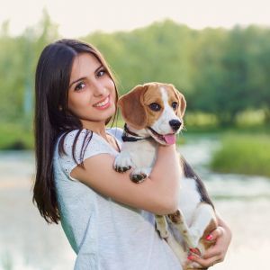 Woman holding a beagle in her arms outside