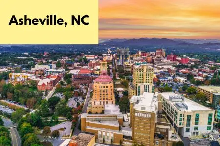 Title on page Asheville, NC - Aerial view of downtown Asheville with tall buildings and the sun-setting