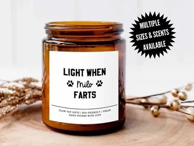 Candle in a jar with the words "Light When Dog Farts" on a white label.