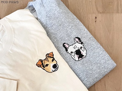 Two t-shirts with custom embroidered dog's image on chest area by Modpawsus