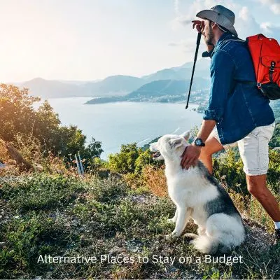 Happyoodles.com - Title:Alternative Places to Stay on a Budget - Dog and man hiking with views.